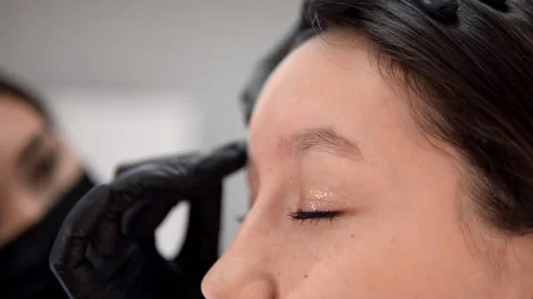 The master wipes his eyebrows with an antiseptic Stockbeeldmateriaal 146530632
