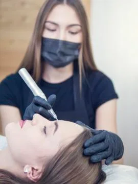 Master at work with the eyebrows makes microbleeding tattoo . Microblading Stock Photos
