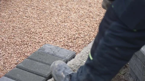 The master worker in gloves lays paving tile stones on sidewalk pavement, slo Vídeo Stock 330119634