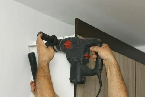 The master working with drill over new kitchen cases Foto stock