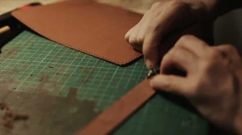 Master working with leather trims the corners of the blank Stock Footage 54424594