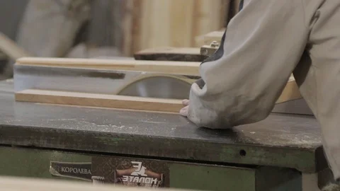Master working with wood on the machine. A man in a gray jacket with a car and a Stock Footage 94103257