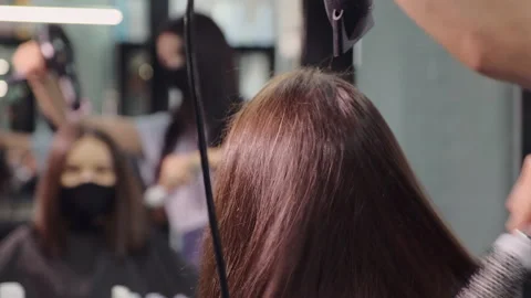 Master works with client hair using brush and dryer in salon Stock Footage 140499614