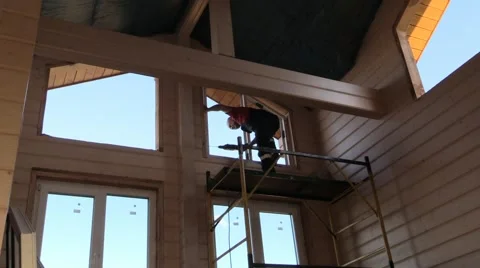 Master works, drill on the scaffolding to insert window in wooden house Stock Footage 67186634