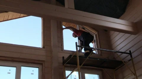 Master works, drill on the scaffolding to insert window in wooden house Stock Footage 67186638