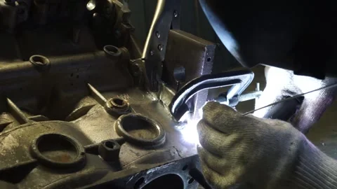 Master works welding with the engine disassembled on the table Stock Footage 145660882