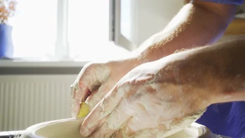 Masterclass teacher holds hand on rotating clayware closeup Stock Footage 139192070