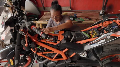 Masterful Repair of the Engine of an Orange Motorcycle by a 50 Year Old Asian Stock Footage 256091093