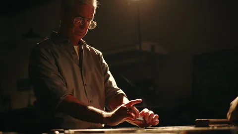 Mastering the art of newspaper printing in a dark, atmospheric workshop Stock Footage 320023447
