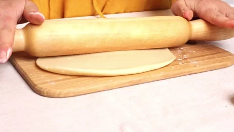 Mastering the art of rolling dough with precision in a cozy kitchen setting Stock-Footage 295279060