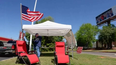 Masters golf ticket scalper tent and people with parked cars clear blue sky Stock Footage 174736242