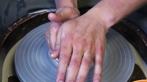 The master's hand controls the pressure of the potter's apprentice's hands Video stock 165553494