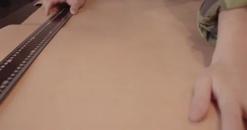 Master's hand with a ruler while working with leather. Stock Footage 147495991