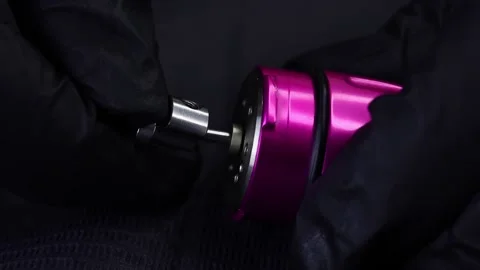 Master's hands are holding a tattoo machine and trying to put on the eccentric Stock Footage 165540974