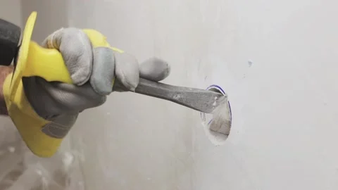 The master’s hands in gloves knock out a niche in the wall 動画素材 147172884