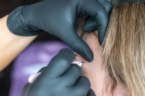 Masters hands make eyebrow shape with tweezers. Lack pain without blood and Stock Photos