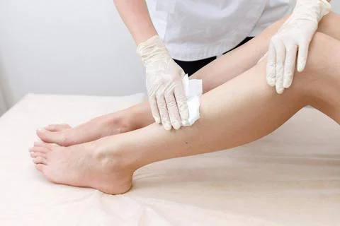 The master's hands will rub their feet with a napkin depilation Stock Photos