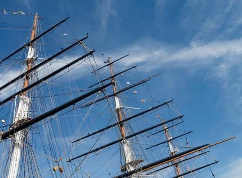 Masts and rigging of a sailing ship against a bright blue sky. 写真素材