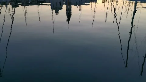Masts of yachts reflected in the water; moored in a picturesque marina earl.. Stock Footage 273984996