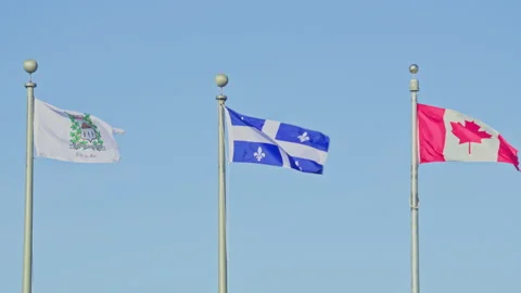 Matane Quebec and Canada flag together in wind blue sky Stock Footage 258274940