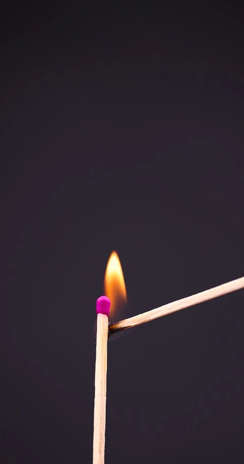 A match burning with an orange flame on a black background, a long large match Stock Footage 265565521