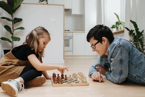 Match of chess between dad and his child daughter. Both having fun Foto stock
