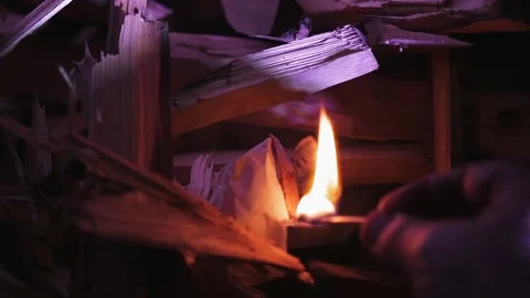 A match in hand sets fire to wood in the stove. Stock Footage 142160607