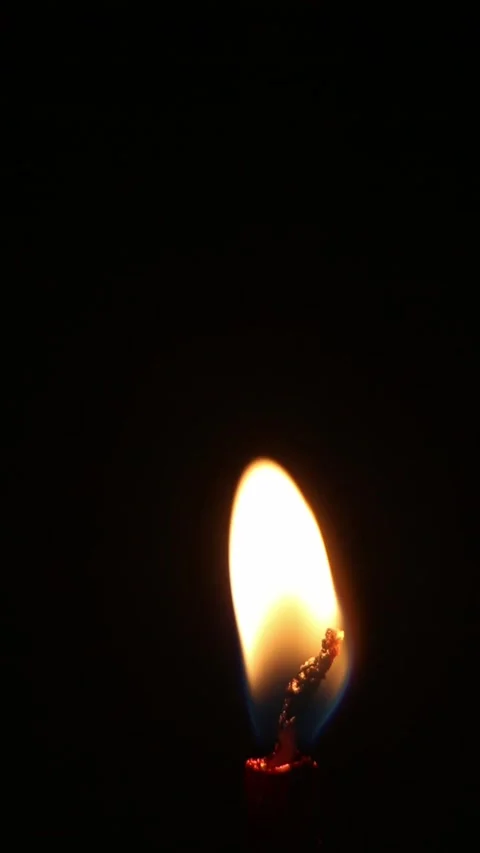 Match igniting candle flame growing bright on black background Stock Footage 340243667