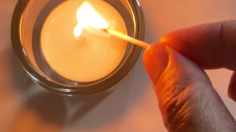 Match igniting a candle wick for cozy atmosphere and relaxation Video stock 338186500