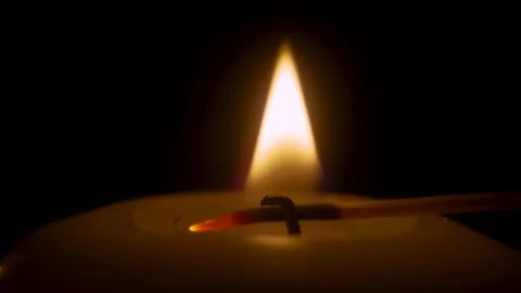 Match lighting close up macro with single candle flame isolated on black Vidéo 236400945