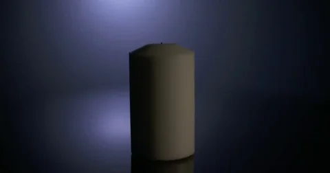 Match lighting a white candle on dark background Stock Footage 74349730