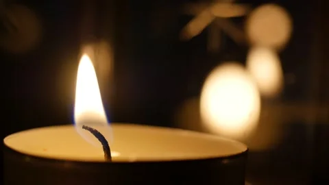 Match lights the candle wick. Lighting a candle in the darkness. Flame lit on a Stock Footage 146453186