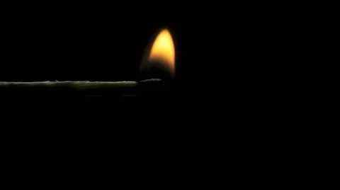 A match lights on a dark black background Vidéo 58056828