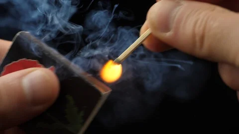 The match moves on the side of the matchbox and light the fire. Vídeo Stock 109489567