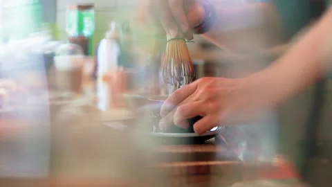 Matcha brewing through glasses slowmotion Video stock 156251396