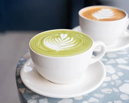 Matcha drink on a table, inside a minimalist coffee shop. Foto stock