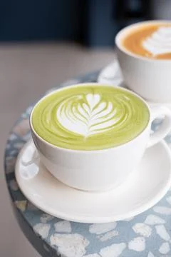 Matcha drink on a table, inside a minimalist coffee shop. Stock Photos