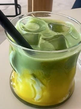Matcha green tea ice cube with milk and mango in glass Stock Photos