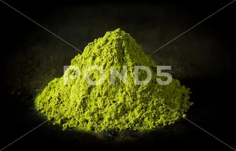 Matcha green tea powder on black cast iron background Stock Photos