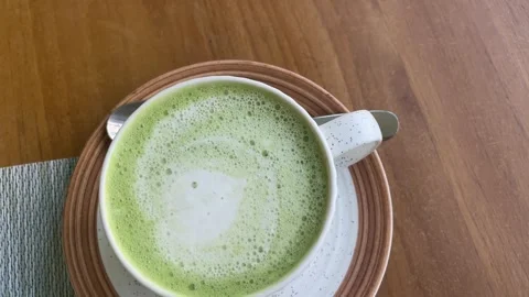 Matcha latte in the cup at the cafe 動画素材 330968466