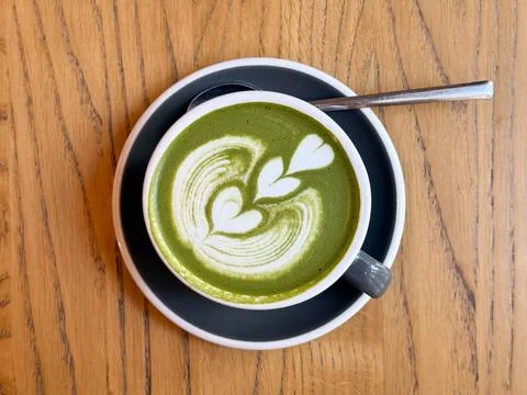 Matcha latte with heart pattern viewed from above. Minimalism, calm energy an Stock Photos