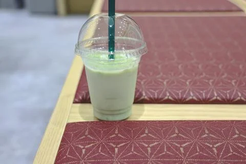 Matcha milkshake drink in plastic cup with straw Stock Photos