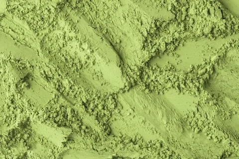Matcha powder spread unevenly creates dynamic background with visible grain.. Stock Photos