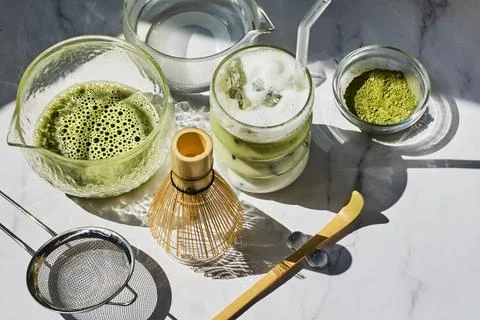 Matcha Preparation. Overhead view of matcha tools with frothy matcha drink Stock Photos