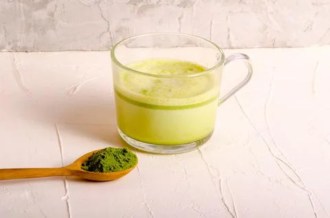 Matcha tea cup with spoon on light grey background Stock Photos