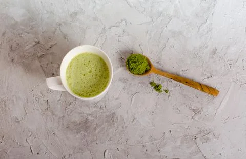 Matcha tea cup with spoon on light grey background Stock-Fotos