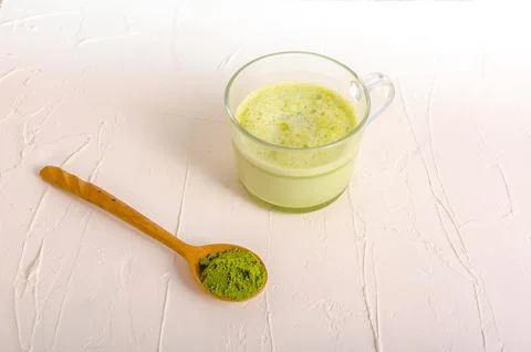 Matcha tea cup with spoon on light grey background Stock Photos