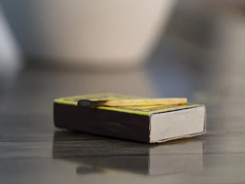 Matchbox with Used Matchstick on Table Stock Photos