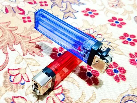 Matches and disposable lighters on patterned carpet surface Stock Photos