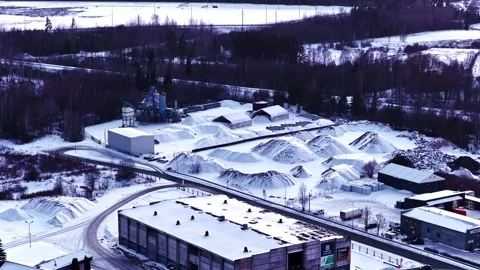 Material handling: industrial yard with raw materials and buildings in winter Видео 330986702